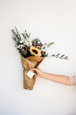 Florist holding a fresh flower bouquet wrapped in kraft paper - Holidaypac wholesale