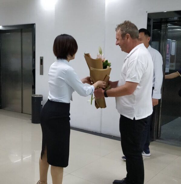 Holidaypac team welcoming European client with flowers at headquarters - factory tour and consultation