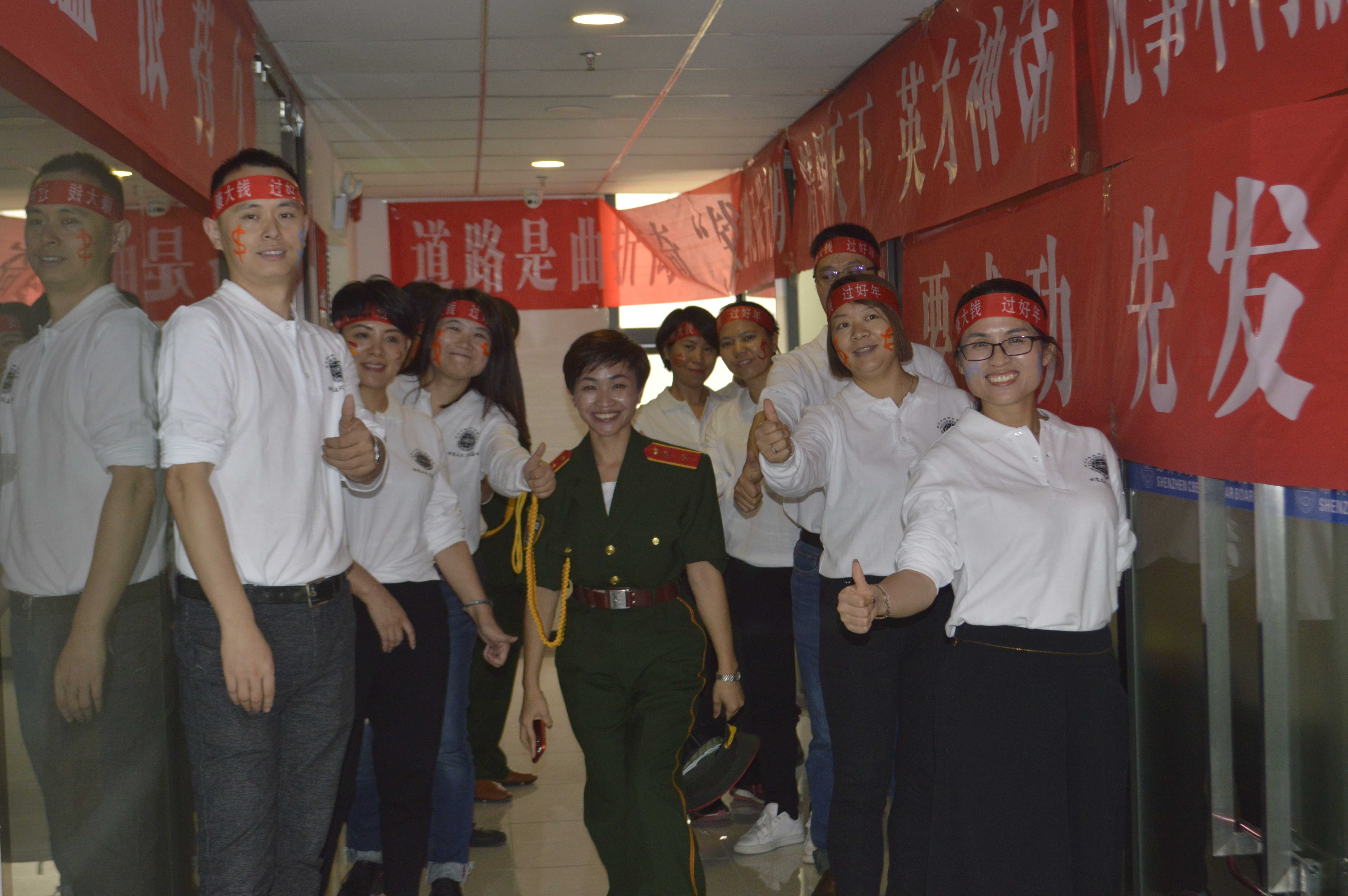Holidaypacfactory team building event with red banners and Holidaypac employees giving thumbs up at company annual kickoff celebration