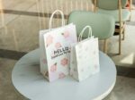 Wholesale kraft paper shopping bags on table - Holidaypac eco-friendly packaging