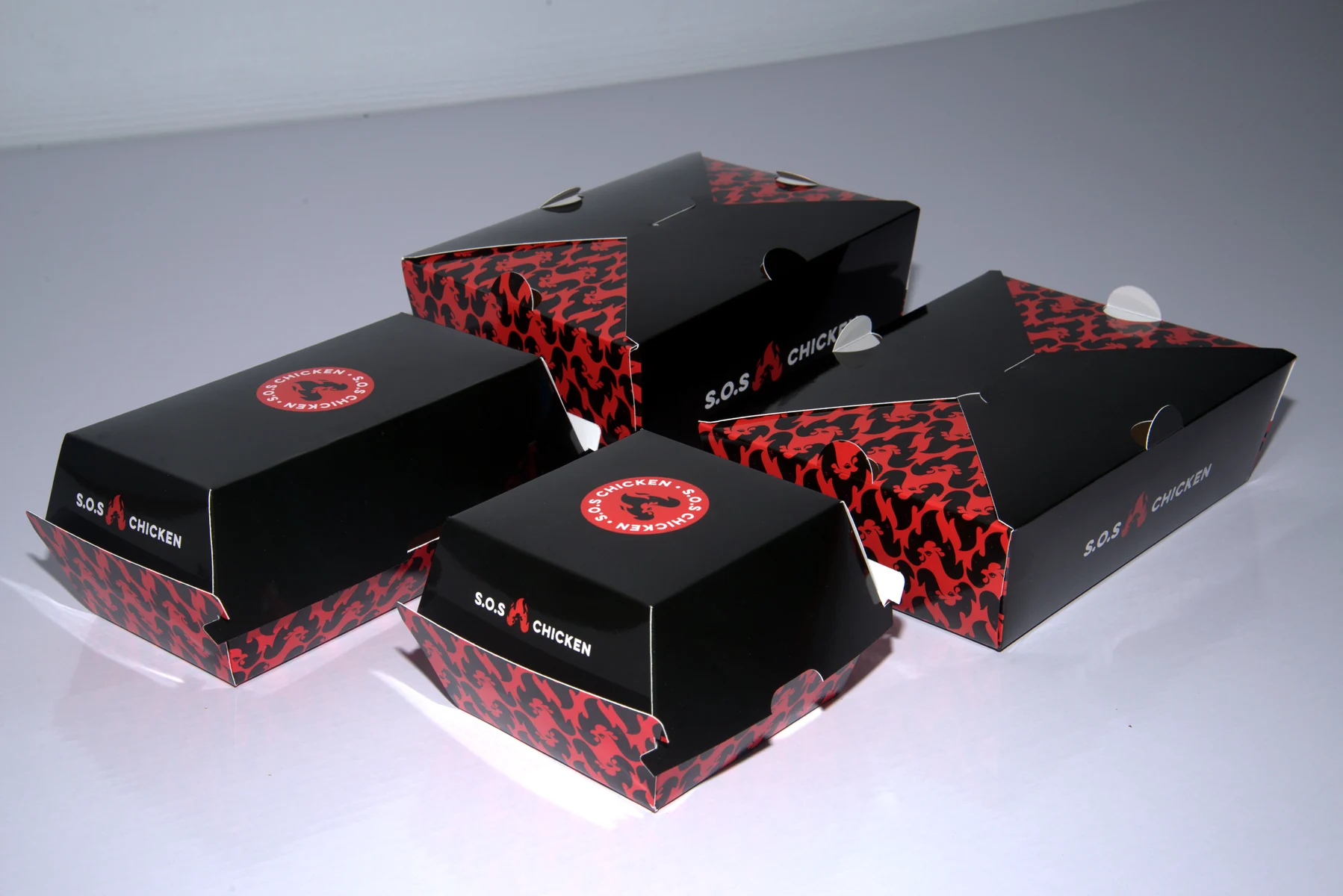 Holidaypacfactory holidaypac factory custom chicken takeaway packaging case study Closed boxes confirm shelf appearance, logo visibility and the shared visual family.