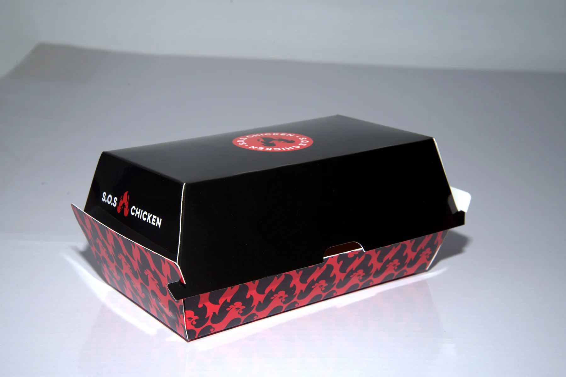 Holidaypacfactory holidaypac factory custom chicken takeaway packaging case study A closed takeaway tray view checks the premium black top and red patterned base.