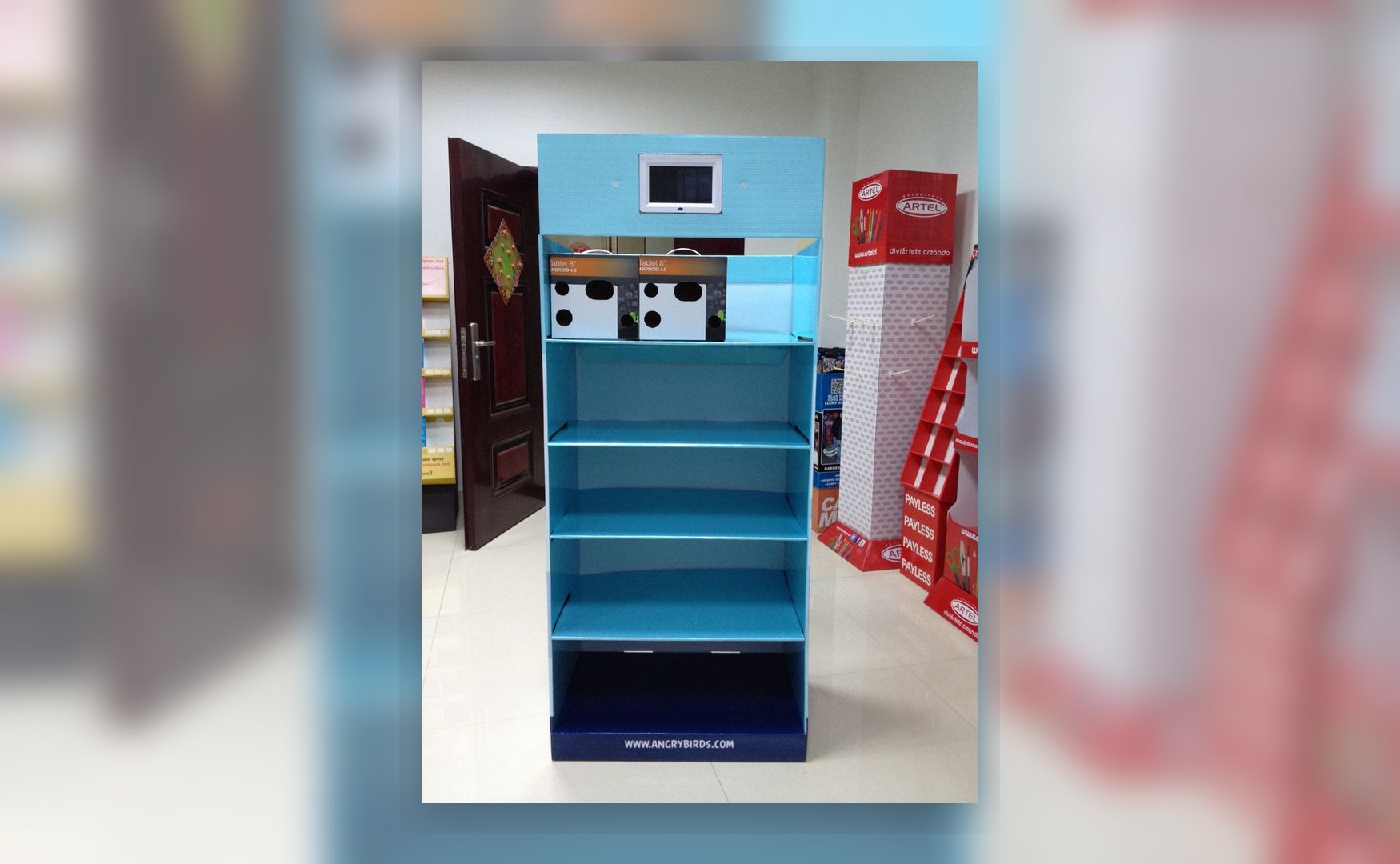 Holidaypacfactory holidaypac factory cardboard display stand with LCD screen straight front view showing the screen position, product shelf area and base branding zone.