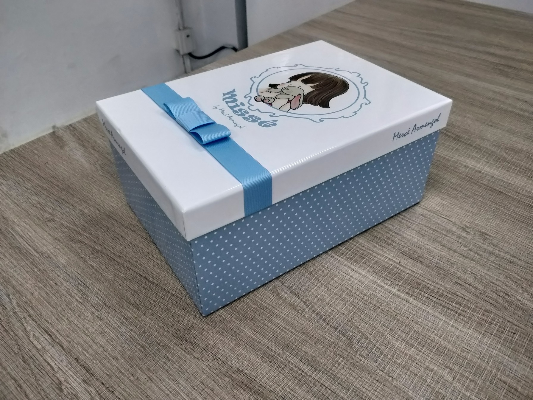 Blue and white rigid doll packaging box shown from a three-quarter angle