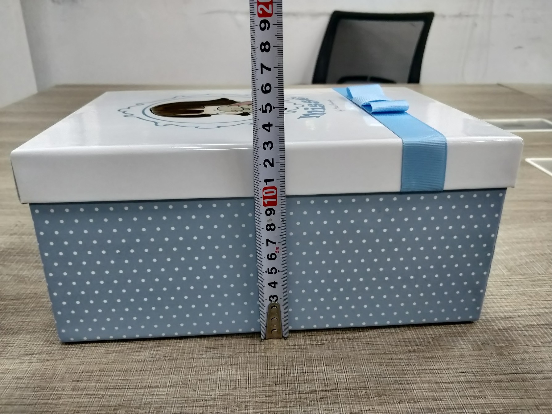 Rigid doll packaging box height check with measuring tape