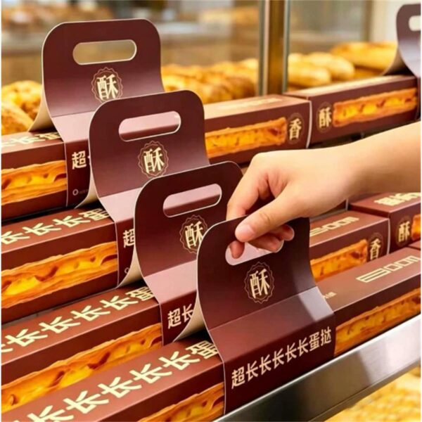 long bakery takeaway box with integrated handle in a pastry counter display Holidaypacfactory