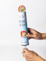 Hand pushing up a sushi roll through the nested paper tube plunger mechanism